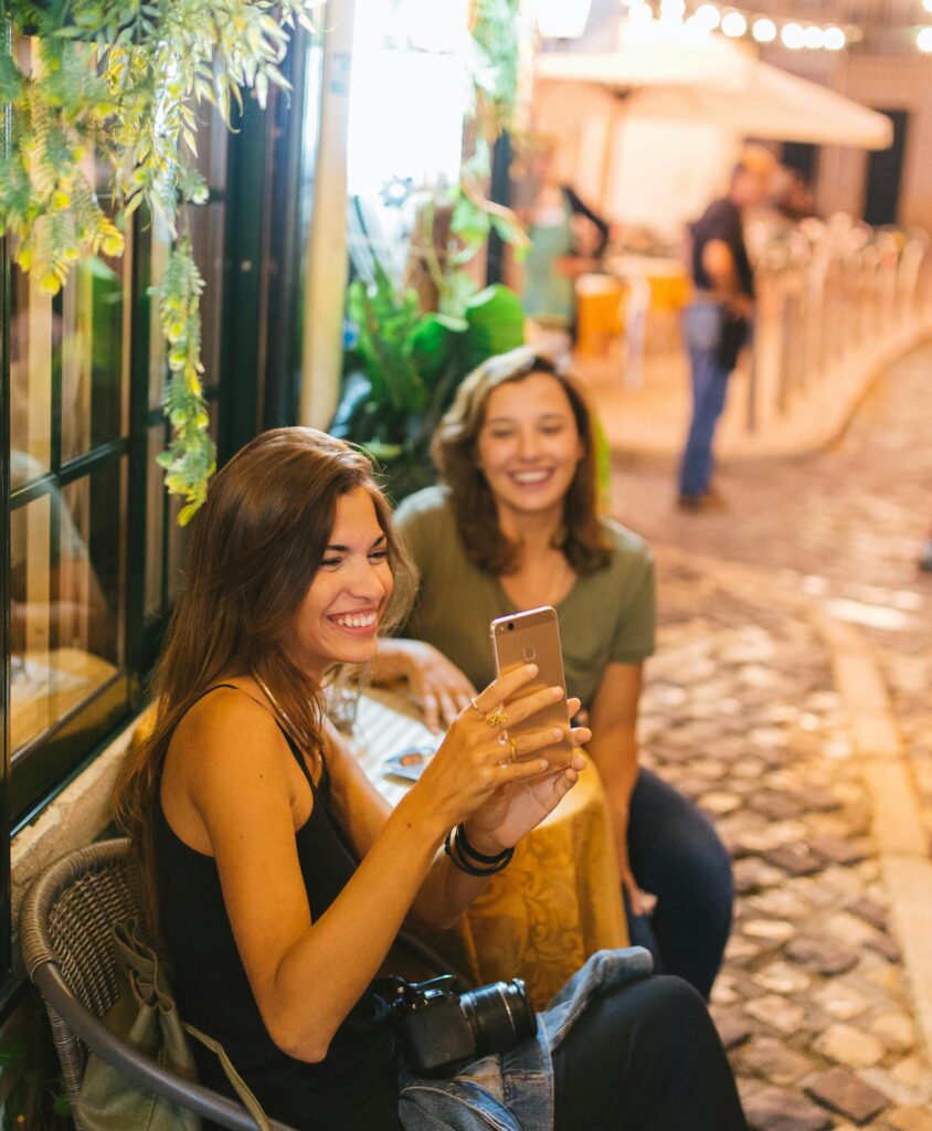Young female travelers in Italy taking a selfie while seated at a table