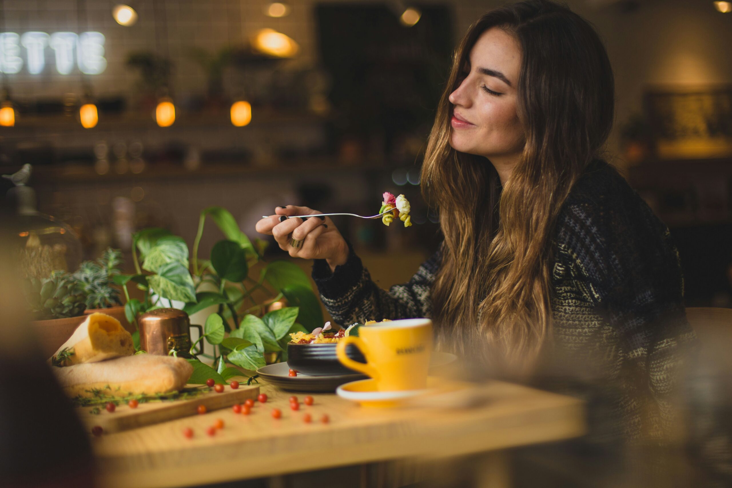 young woman seated at the table eating a meal