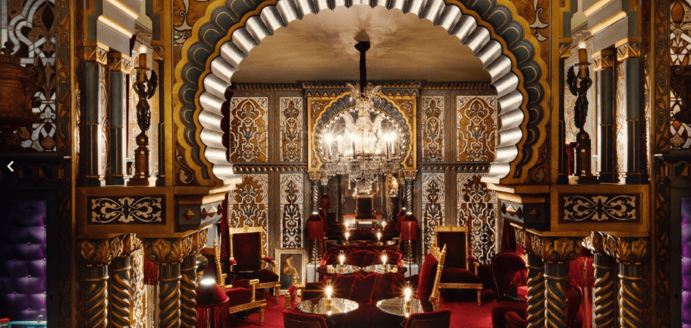 Luxury Parisian lounge adorned with deep red and gold fabrics and elegant Oriental arches