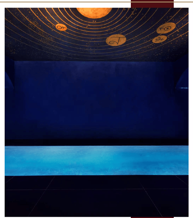 Luxury spa with indoor pool and a celestial blue and gold astrological ceiling.